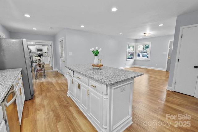 4009 Dunwoody Dr, Charlotte, NC 28215 - kitchen with freestanding refrigerator, white cabinetry, recessed lighting, light wood finished floors, and a kitchen island