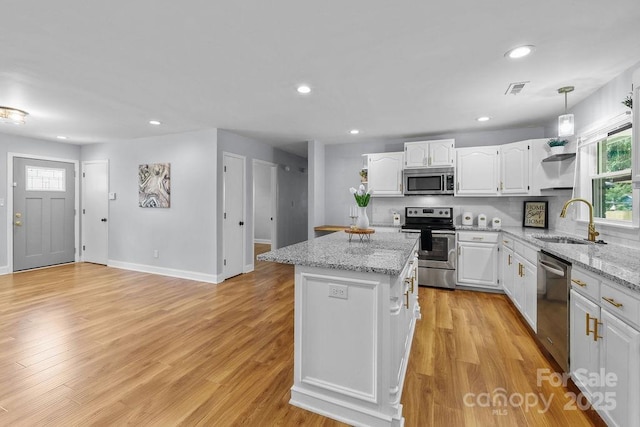 4009 Dunwoody Dr, Charlotte, NC 28215 - kitchen with stainless steel appliances, a sink, open shelves, white cabinets, and a center island