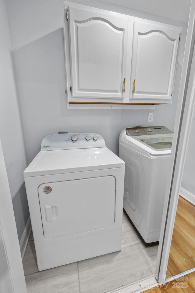 4009 Dunwoody Dr, Charlotte, NC 28215 - laundry area with washing machine and dryer, cabinet space, light wood finished floors, and baseboards