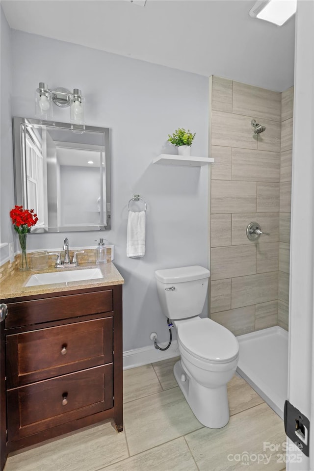 4009 Dunwoody Dr, Charlotte, NC 28215 - bathroom with toilet, baseboards, tiled shower, and vanity