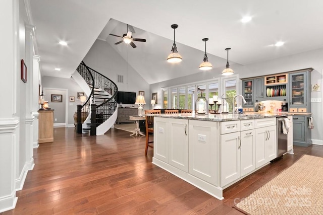 kitchen with vaulted ceiling, a sink, open floor plan, ceiling fan, and decorative light fixtures