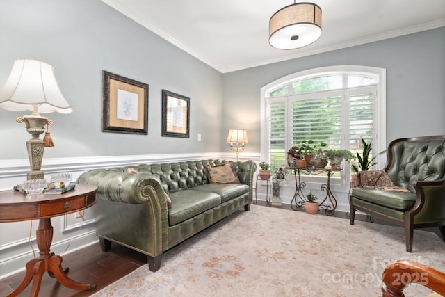 living room with wainscoting, wood finished floors, and ornamental molding
