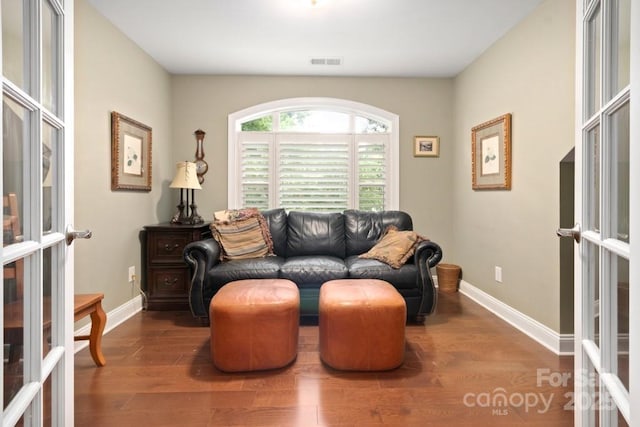 sitting room with french doors, wood finished floors, visible vents, and baseboards