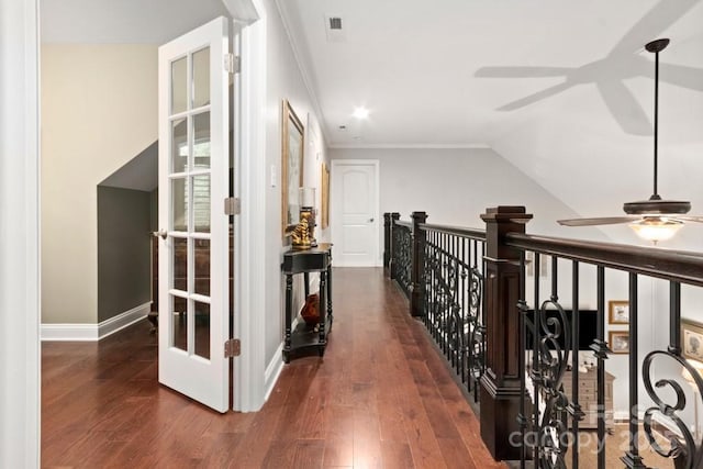 corridor with baseboards, ornamental molding, and wood finished floors