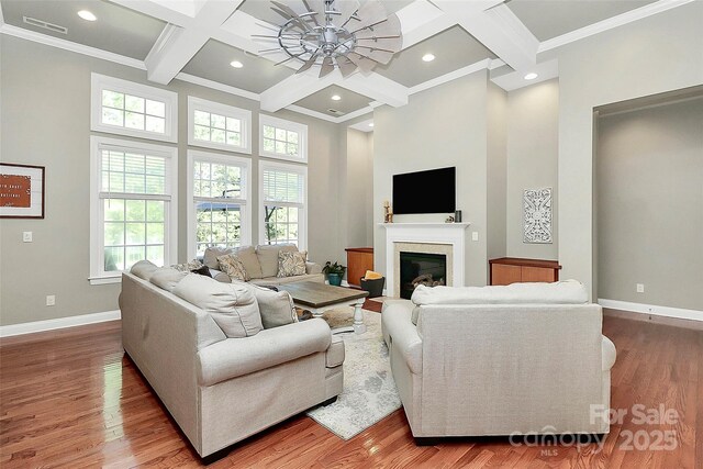1105 Hoyle Ln, Waxhaw, NC 28173 - living area featuring wood finished floors, coffered ceiling, baseboards, a high ceiling, and beam ceiling