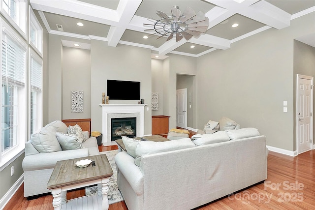 1105 Hoyle Ln, Waxhaw, NC 28173 - living room featuring a fireplace with flush hearth, ceiling fan, coffered ceiling, and baseboards