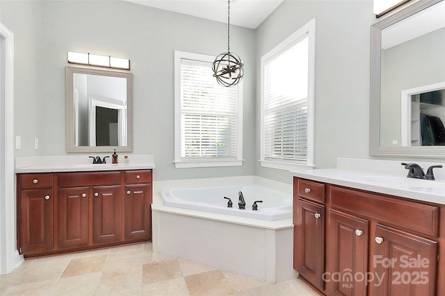 1105 Hoyle Ln, Waxhaw, NC 28173 - full bathroom featuring a garden tub, two vanities, a sink, and an inviting chandelier