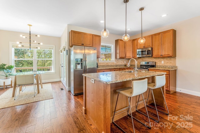 30 Asher Ln, Arden, NC 28704 - kitchen with stainless steel appliances, hardwood / wood-style flooring, brown cabinetry, light stone counters, and recessed lighting