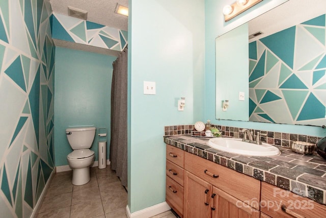 bathroom with toilet, visible vents, baseboards, tile patterned flooring, and vanity