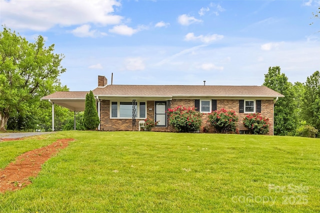 ranch-style home with brick siding, a front lawn, and an attached carport