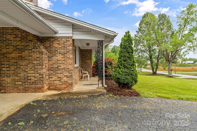 property entrance featuring brick siding and a yard
