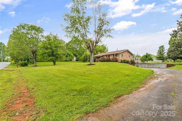 view of yard with aphalt driveway