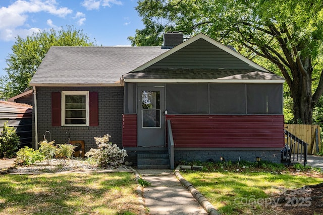 3919 Sarah Dr Unit 14, Charlotte, NC 28217 - bungalow featuring a chimney, central AC unit, roof with shingles, brick siding, and a sunroom
