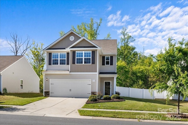 traditional-style house with fence, an attached garage, driveway, stone siding, and a front yard