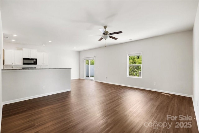 unfurnished living room with a ceiling fan, baseboards, recessed lighting, and dark wood finished floors