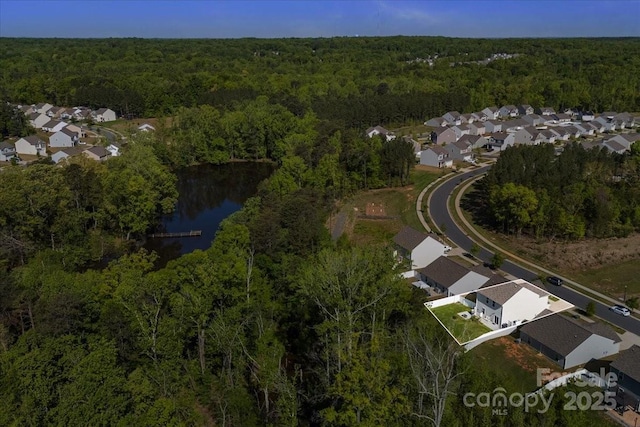 aerial view with a forest view, a residential view, and a water view