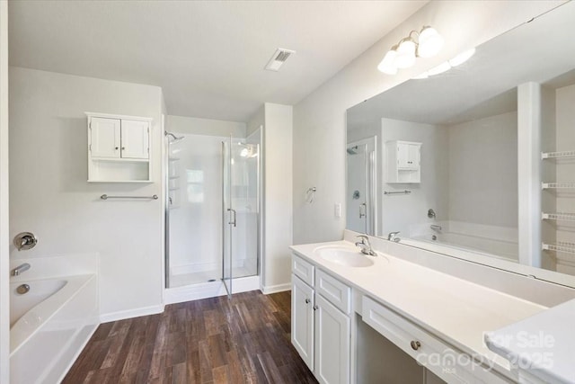 full bath with a garden tub, wood finished floors, a stall shower, vanity, and visible vents
