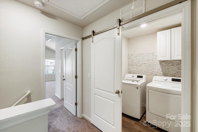 clothes washing area featuring dark carpet, washer and dryer, and cabinet space