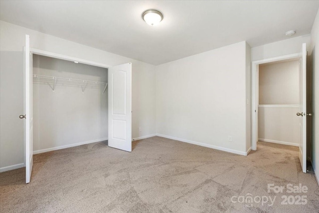 unfurnished bedroom with carpet floors, a closet, and baseboards