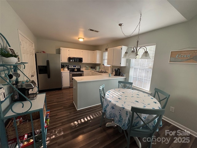 kitchen with a sink, stainless steel appliances, light countertops, a peninsula, and visible vents