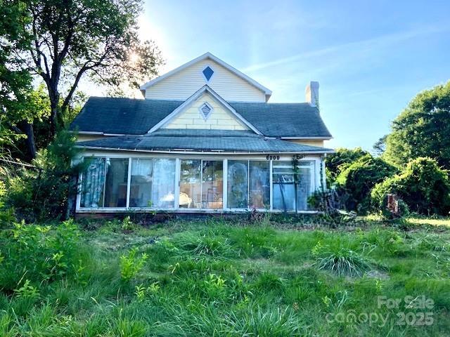6000 S Main St, Salisbury, NC 28147 - back of property with a chimney, a sunroom, and roof with shingles