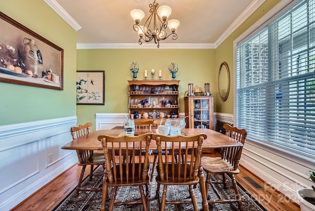 10836 Maryanna Ct, Charlotte, NC 28213 - dining space featuring visible vents, crown molding, wood finished floors, a wainscoted wall, and an inviting chandelier