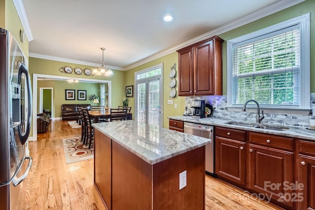 10836 Maryanna Ct, Charlotte, NC 28213 - kitchen with appliances with stainless steel finishes, light stone counters, a sink, light wood-type flooring, and a kitchen island