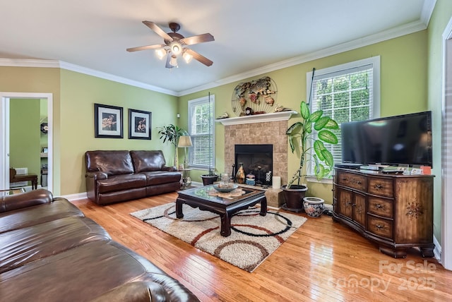 10836 Maryanna Ct, Charlotte, NC 28213 - living area featuring crown molding, a ceiling fan, a tiled fireplace, and hardwood / wood-style flooring