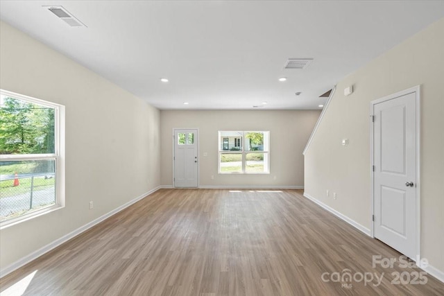 808 Carolyn Ave, Kannapolis, NC 28083 - unfurnished living room with light wood-type flooring, visible vents, baseboards, and a healthy amount of sunlight
