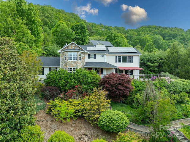 106 Thistle Tree Way, Weaverville, NC 28787 - view of front facade with a wooded view, roof mounted solar panels, and stone siding