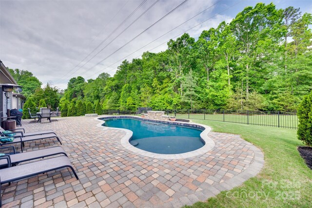 view of swimming pool featuring a patio, a fenced backyard, a lawn, and a fenced in pool
