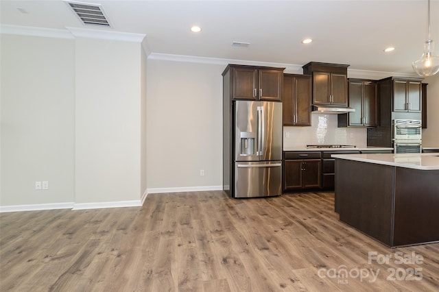 604 Tudor Park Way, Charlotte, NC 28211 - kitchen featuring ornamental molding, stainless steel appliances, light countertops, under cabinet range hood, and visible vents