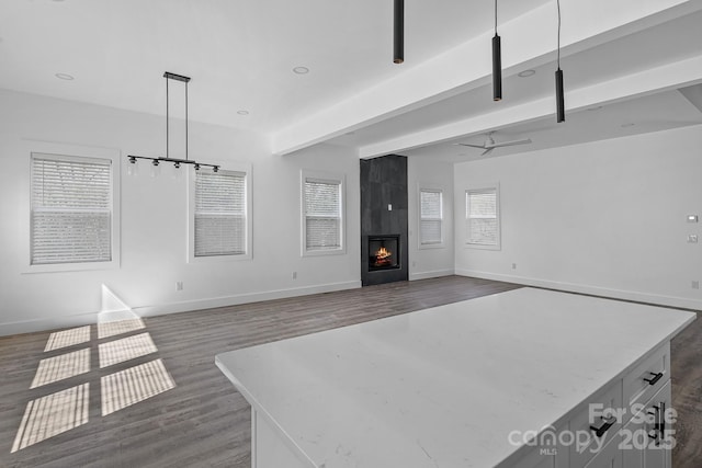 unfurnished living room featuring a fireplace, wood finished floors, and baseboards