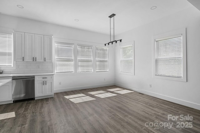 unfurnished dining area featuring baseboards, recessed lighting, a sink, and dark wood-style flooring