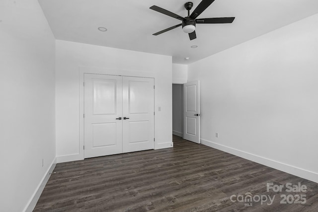 unfurnished bedroom with dark wood finished floors, baseboards, ceiling fan, and a closet