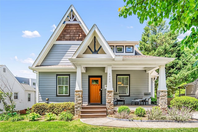 craftsman-style house featuring a porch and roof with shingles