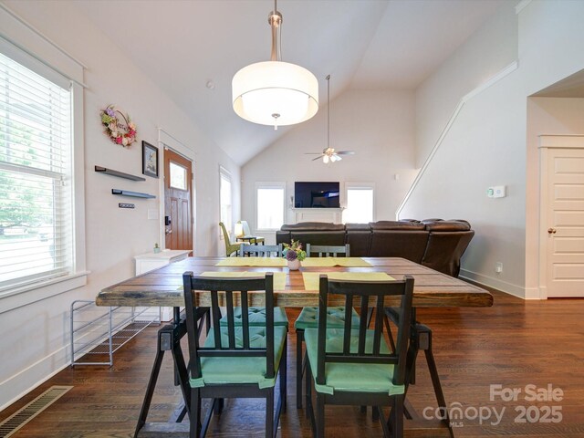 dining space with lofted ceiling, wood finished floors, ceiling fan, and baseboards