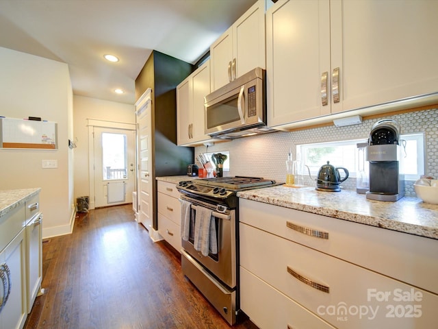 kitchen featuring stainless steel appliances, decorative backsplash, dark wood-type flooring, recessed lighting, and light stone countertops