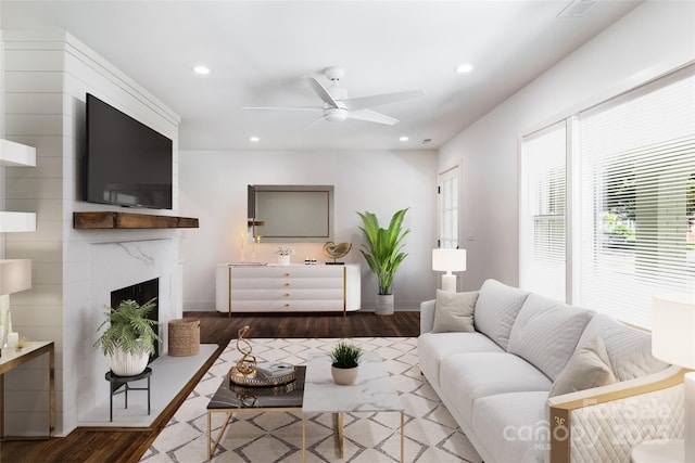 living area featuring recessed lighting, a ceiling fan, wood finished floors, and a premium fireplace