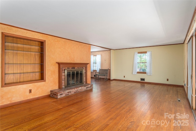 220 Ridge Rd, Waynesville, NC 28786 - unfurnished living room with built in features, a fireplace, wood finished floors, and crown molding