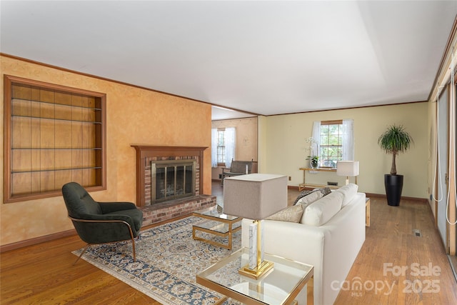 220 Ridge Rd, Waynesville, NC 28786 - living area featuring built in shelves, wood finished floors, a fireplace, and crown molding