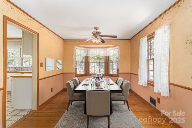 220 Ridge Rd, Waynesville, NC 28786 - dining room featuring wood finished floors, a ceiling fan, healthy amount of natural light, and wainscoting