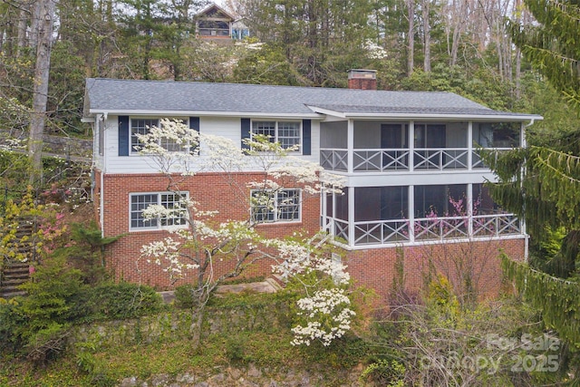 220 Ridge Rd, Waynesville, NC 28786 - view of front facade with a chimney, a sunroom, brick siding, and roof with shingles