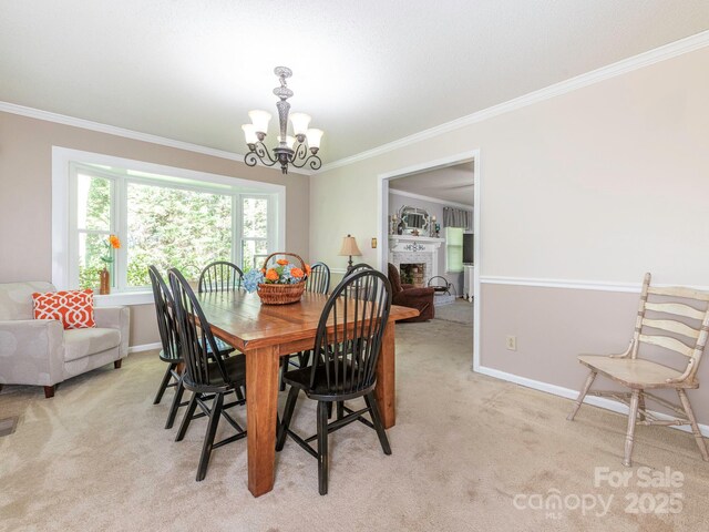 dining area with baseboards, an inviting chandelier, light colored carpet, and crown molding