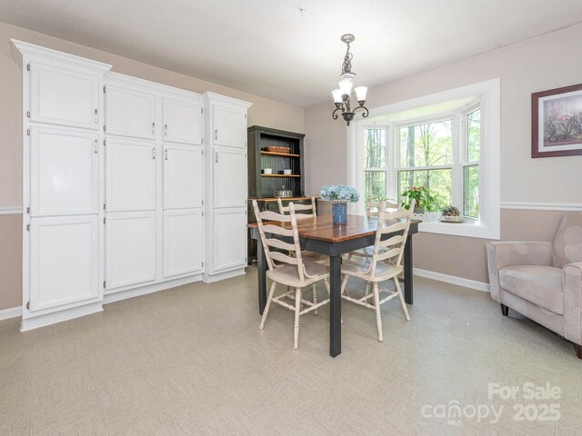 dining room with baseboards and a notable chandelier