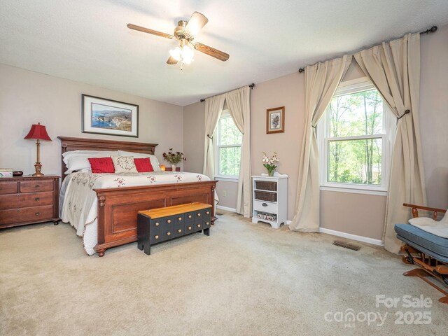 carpeted bedroom featuring baseboards, visible vents, and ceiling fan