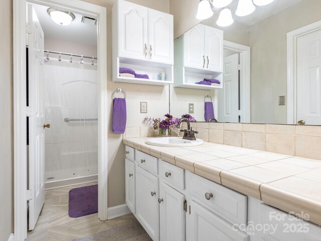bathroom featuring baseboards, vanity, a shower with shower curtain, and visible vents