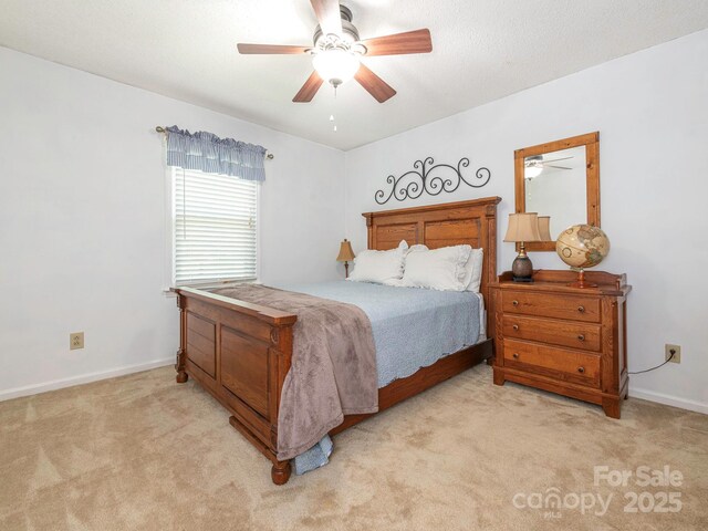 bedroom featuring a ceiling fan, baseboards, and light carpet