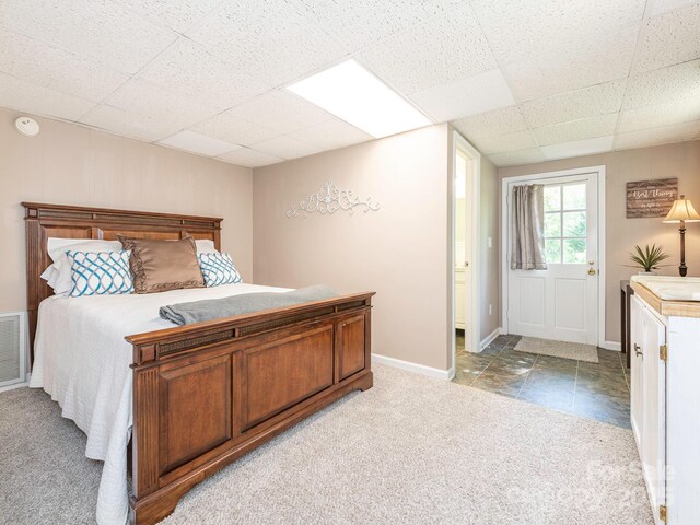 carpeted bedroom featuring baseboards, visible vents, and a paneled ceiling
