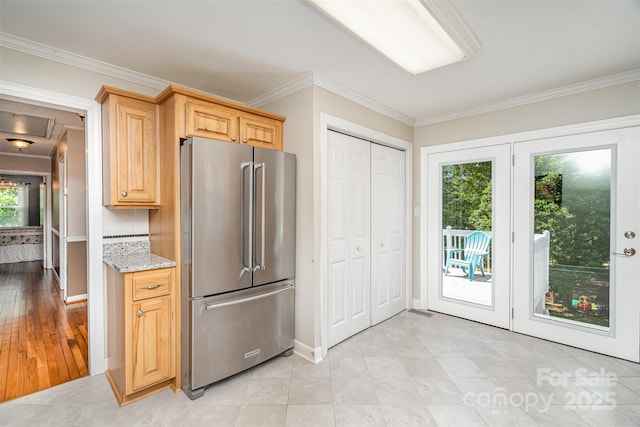kitchen featuring crown molding, baseboards, light stone counters, high end fridge, and light brown cabinets